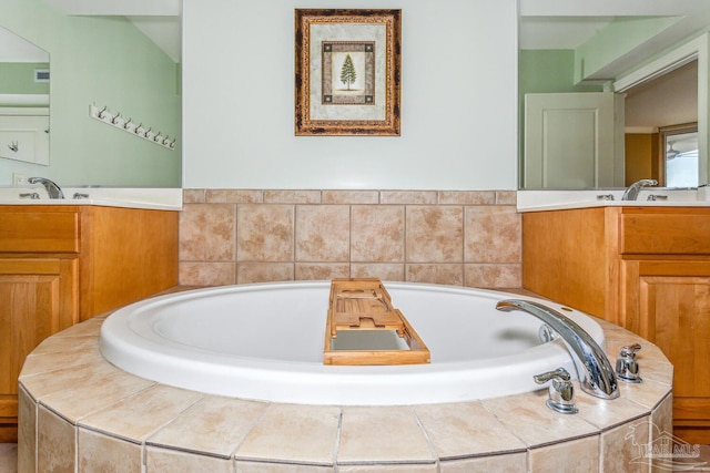 bathroom with tiled tub and vanity