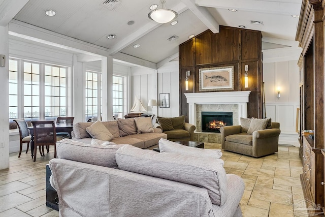 living room with a tiled fireplace and vaulted ceiling with beams