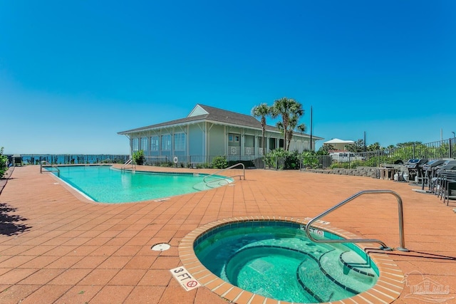 view of swimming pool featuring a patio and a hot tub