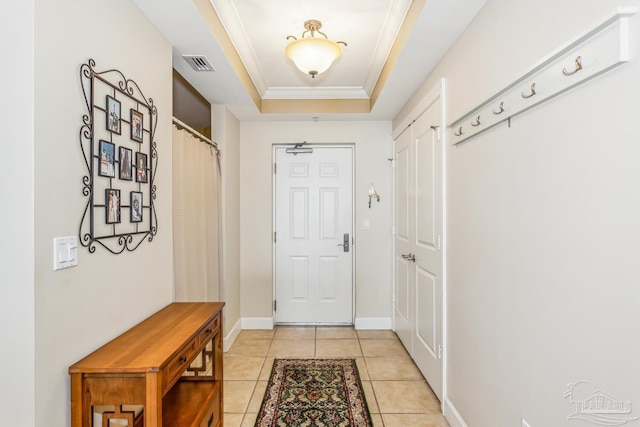 mudroom with a raised ceiling, crown molding, and light tile patterned flooring