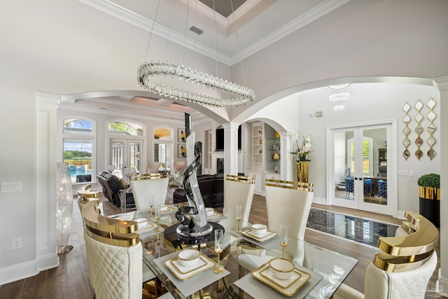 6126 E Fence Rd, Pensacola, FL 32526 - dining room with french doors, arched walkways, decorative columns, crown molding, and healthy amount of natural light