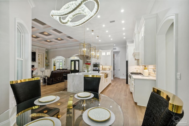 6126 E Fence Rd, Pensacola, FL 32526 - dining space with crown molding, arched walkways, light wood-style floors, a chandelier, and coffered ceiling