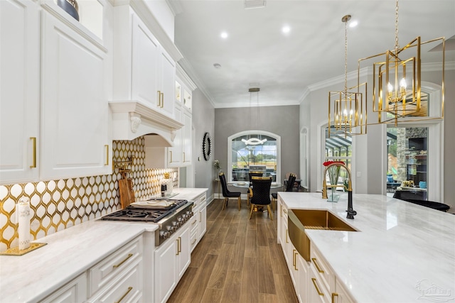 6126 E Fence Rd, Pensacola, FL 32526 - kitchen with stainless steel gas cooktop, a chandelier, white cabinets, dark wood finished floors, and crown molding