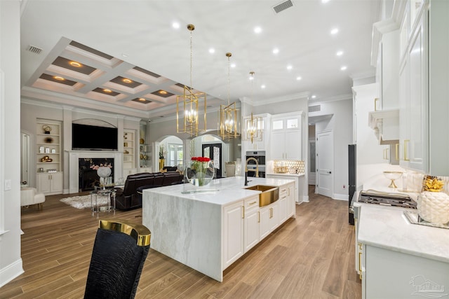 6126 E Fence Rd, Pensacola, FL 32526 - kitchen with ornamental molding, white cabinets, arched walkways, a large island with sink, and open floor plan
