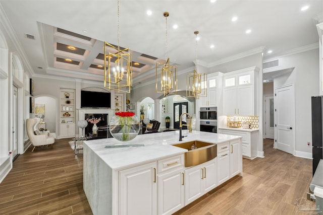 6126 E Fence Rd, Pensacola, FL 32526 - kitchen with arched walkways, a chandelier, open floor plan, crown molding, and white cabinets