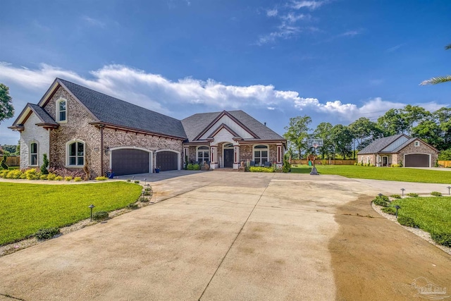 6126 E Fence Rd, Pensacola, FL 32526 - french country inspired facade with concrete driveway, a front yard, brick siding, and an attached garage
