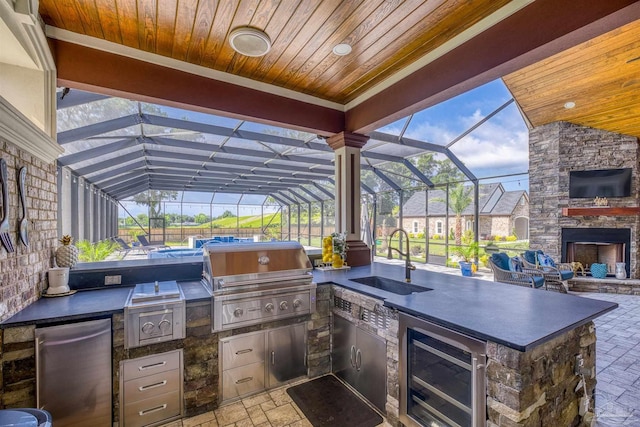 6126 E Fence Rd, Pensacola, FL 32526 - view of patio / terrace with exterior kitchen, an outdoor stone fireplace, wine cooler, and glass enclosure