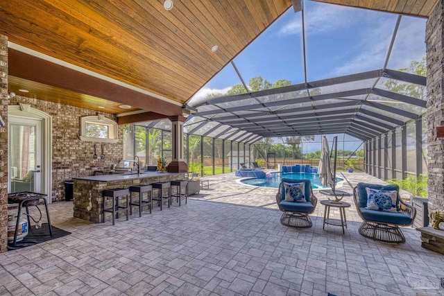 6126 E Fence Rd, Pensacola, FL 32526 - view of patio with an outdoor bar, a pool with connected hot tub, and a lanai
