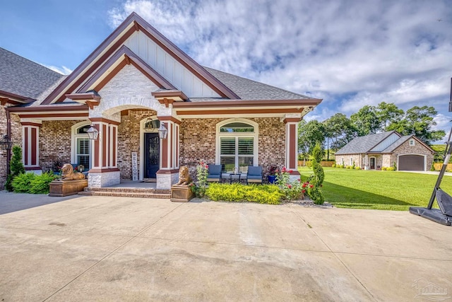 6126 E Fence Rd, Pensacola, FL 32526 - craftsman-style house featuring covered porch, a front lawn, brick siding, board and batten siding, and roof with shingles