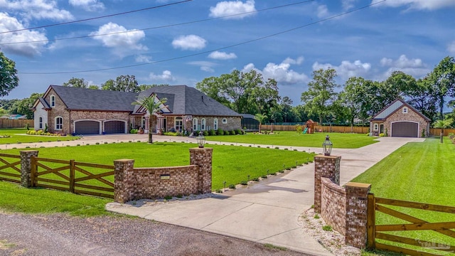 6126 E Fence Rd, Pensacola, FL 32526 - view of front of home with concrete driveway, a playground, stone siding, and an attached garage