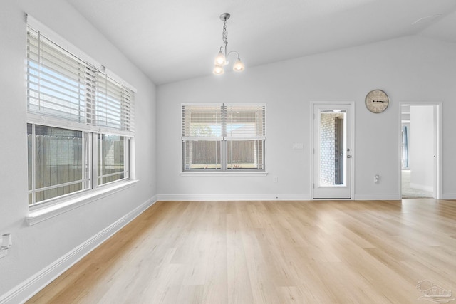 unfurnished dining area with plenty of natural light, light hardwood / wood-style floors, and vaulted ceiling