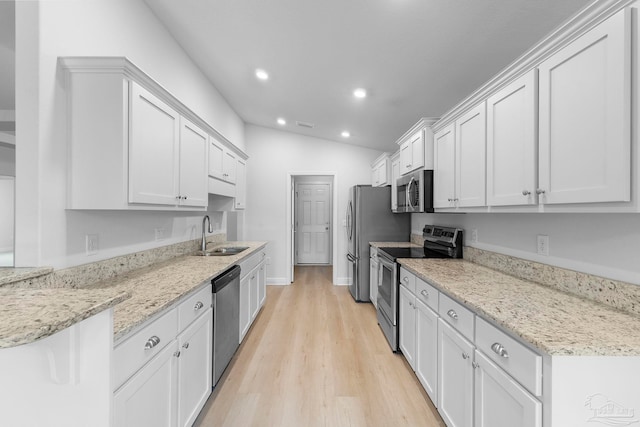 kitchen with sink, light hardwood / wood-style floors, white cabinetry, stainless steel appliances, and lofted ceiling