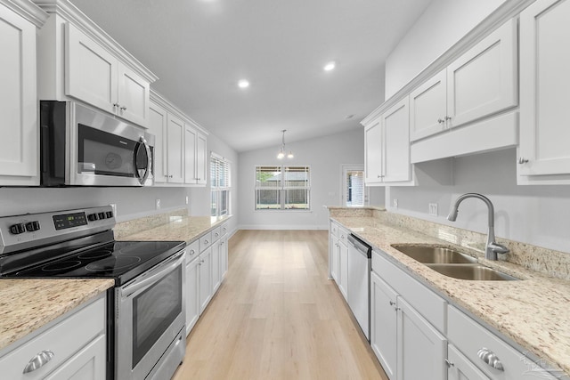 kitchen with sink, light wood-type flooring, light stone countertops, vaulted ceiling, and stainless steel appliances