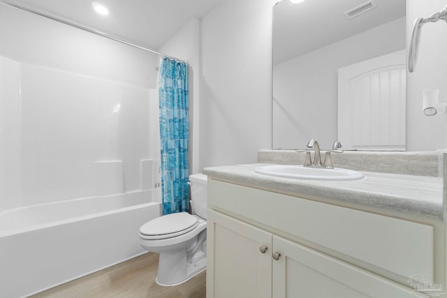 full bathroom with toilet, hardwood / wood-style floors, vanity, and shower / bath combo