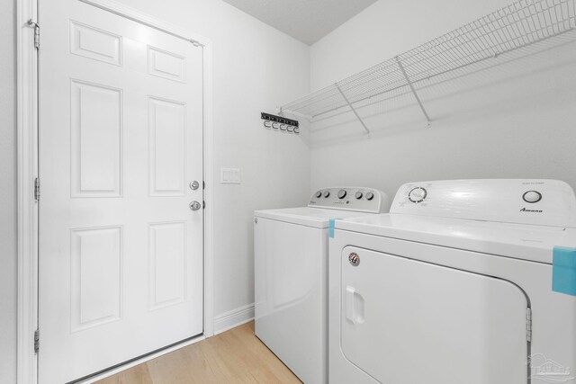 washroom with light hardwood / wood-style floors and separate washer and dryer