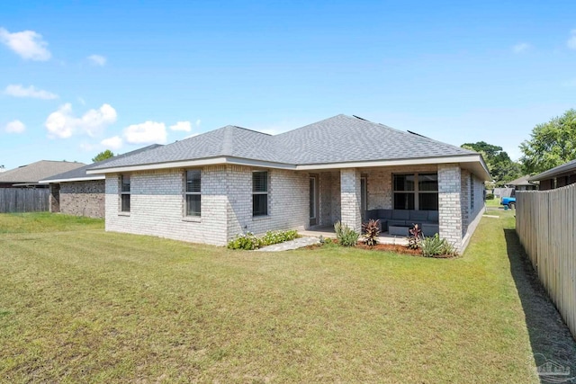 rear view of property with a patio area and a lawn