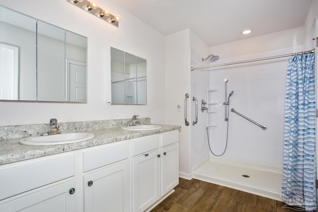 bathroom featuring walk in shower, wood-type flooring, and vanity