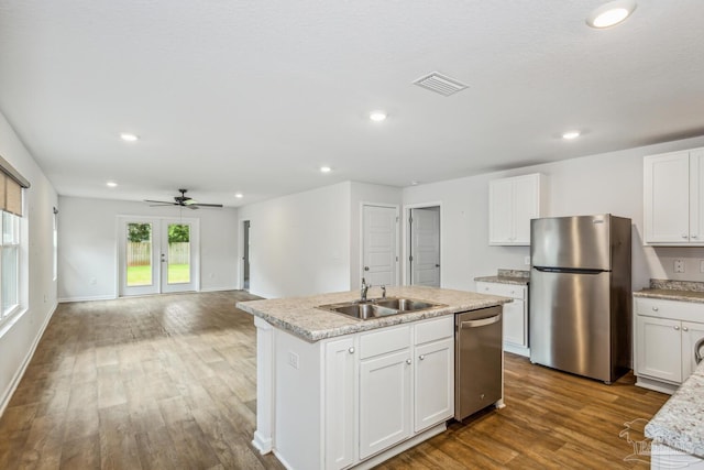 kitchen featuring white cabinetry, sink, hardwood / wood-style flooring, a kitchen island with sink, and stainless steel appliances