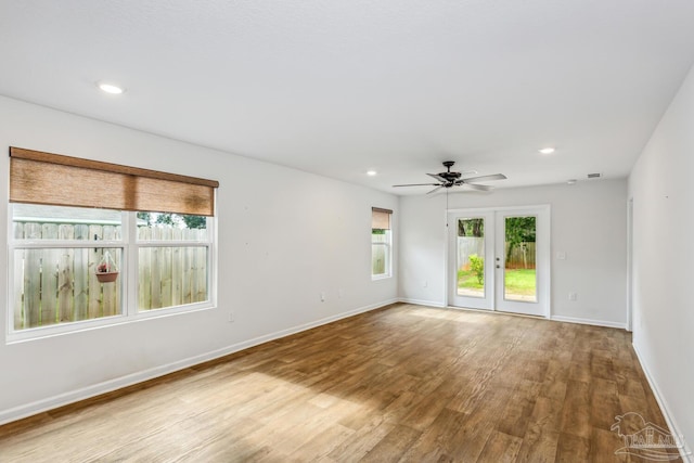 empty room with wood-type flooring, ceiling fan, and french doors