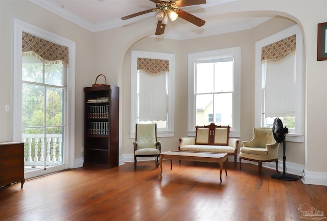 living area with hardwood / wood-style flooring, ornamental molding, and ceiling fan