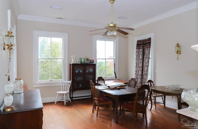 dining space with crown molding, ceiling fan, and hardwood / wood-style floors