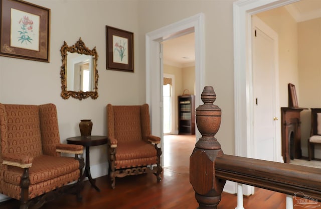 sitting room with hardwood / wood-style flooring and ornamental molding