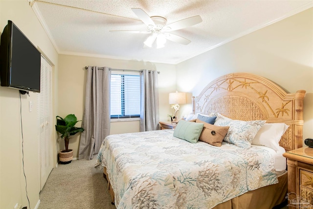 carpeted bedroom featuring a closet, a textured ceiling, ceiling fan, and crown molding