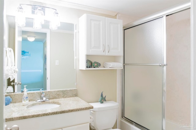 bathroom with toilet, vanity, and ornamental molding