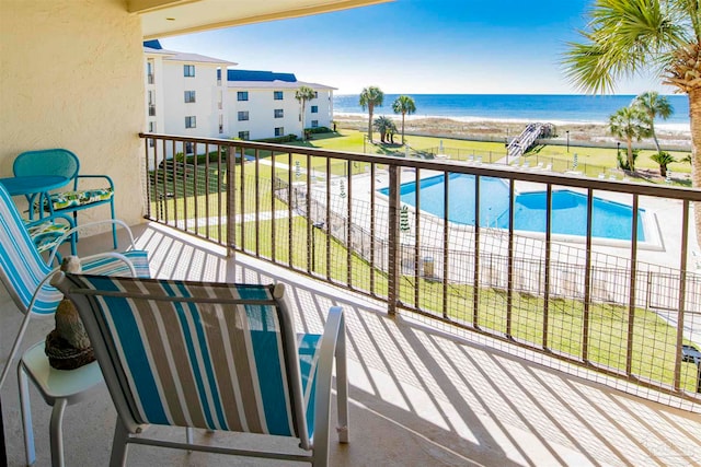 balcony featuring a water view and a fenced in pool