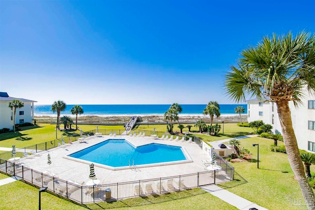 view of pool featuring a water view, a yard, and a patio area