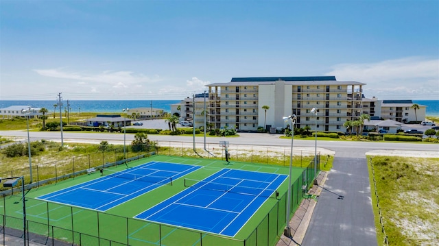 view of tennis court featuring a water view