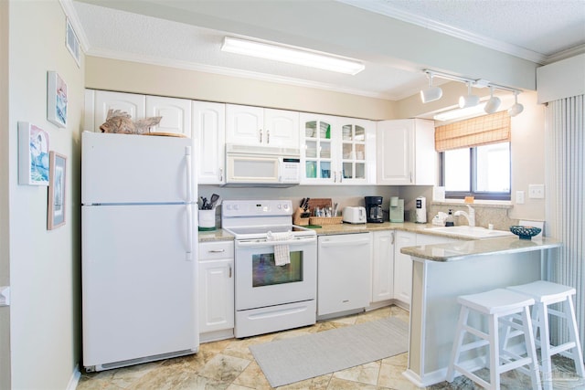 kitchen with white cabinetry, kitchen peninsula, white appliances, and ornamental molding