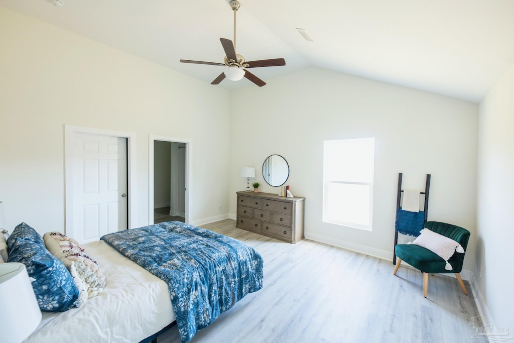 bedroom with light wood-type flooring, vaulted ceiling, and ceiling fan