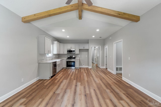 kitchen featuring light wood finished floors, baseboards, light countertops, recessed lighting, and stainless steel appliances