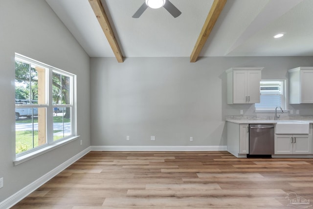 kitchen featuring baseboards, a sink, light countertops, dishwasher, and beamed ceiling