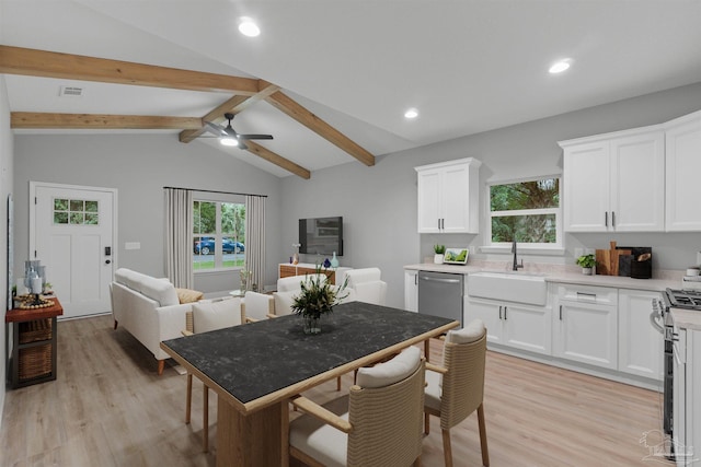 kitchen featuring a sink, plenty of natural light, appliances with stainless steel finishes, and vaulted ceiling with beams