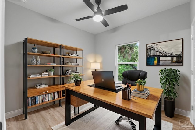 home office featuring light wood-type flooring, baseboards, and ceiling fan