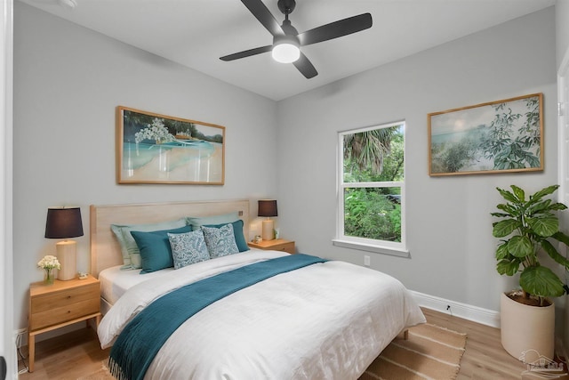 bedroom featuring light wood-style flooring, a ceiling fan, and baseboards