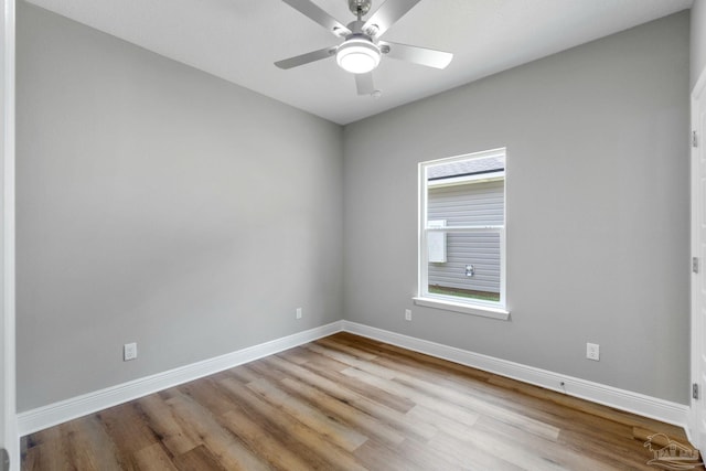 unfurnished room featuring a ceiling fan, wood finished floors, and baseboards