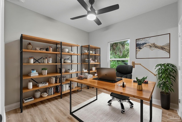 home office featuring a ceiling fan, baseboards, and light wood finished floors