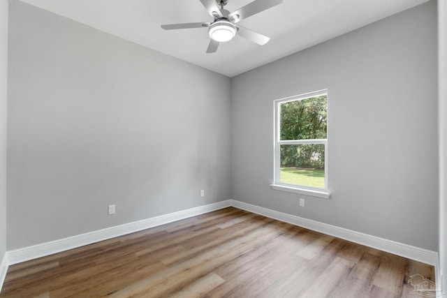 unfurnished room with a ceiling fan, baseboards, and wood finished floors