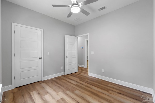 unfurnished bedroom with visible vents, light wood-style floors, baseboards, and ceiling fan