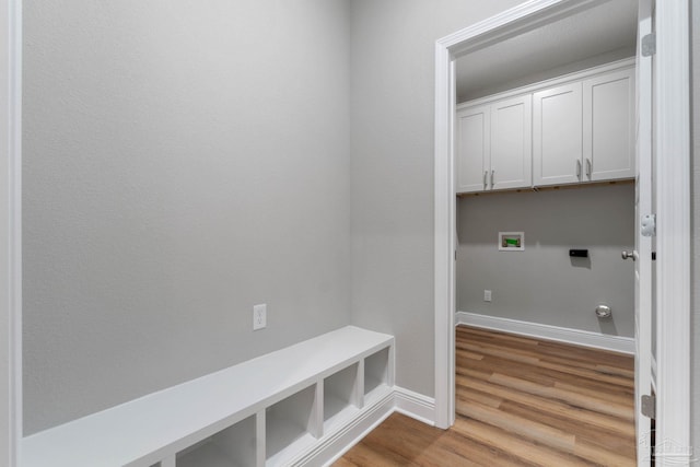 washroom with wood finished floors, baseboards, gas dryer hookup, cabinet space, and washer hookup