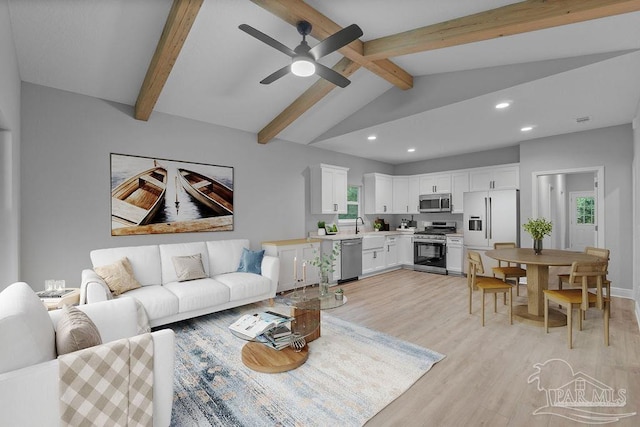 living area featuring lofted ceiling with beams, light wood-type flooring, a ceiling fan, and recessed lighting