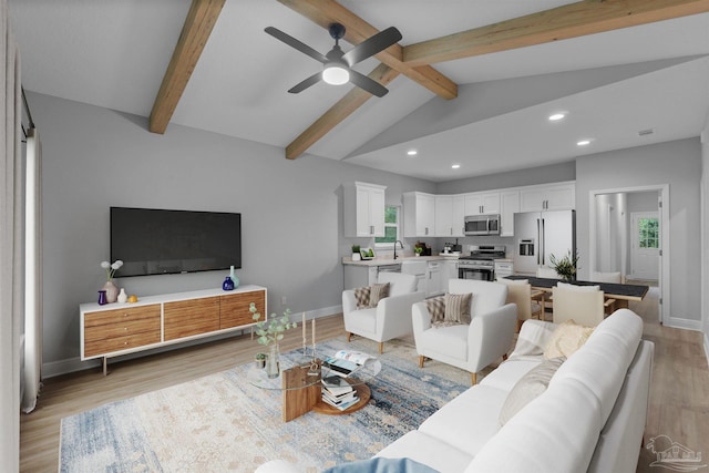 living area featuring baseboards, ceiling fan, lofted ceiling with beams, recessed lighting, and light wood-style floors