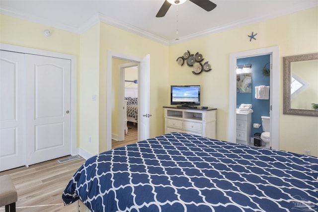 bedroom featuring ensuite bath, ceiling fan, crown molding, light wood-type flooring, and a closet