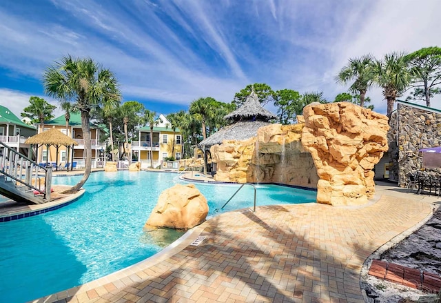 view of pool with a patio and pool water feature