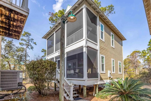 back of house featuring a sunroom and central AC unit