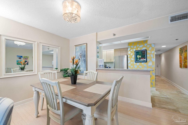 13753 Perdido Key Dr Unit 504, Perdido Key, FL 32507 - dining room featuring baseboards, a textured ceiling, and light wood-style floors