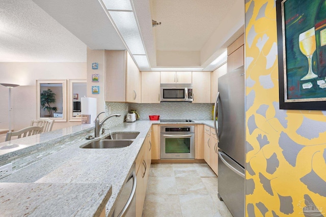 13753 Perdido Key Dr Unit 504, Perdido Key, FL 32507 - kitchen featuring stainless steel appliances, a sink, a textured ceiling, light stone counters, and light brown cabinetry